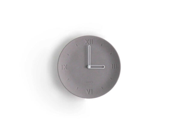 Horloge forme assiette béton gris clair chiffre romain aiguilles blanches