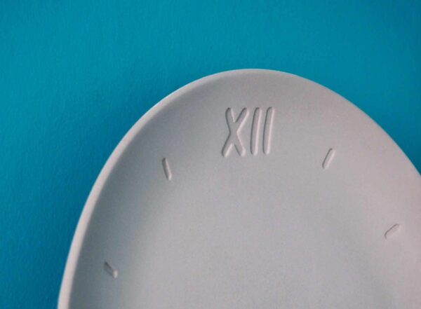 Vue dessus horloge forme assiette béton gris clair chiffre romain