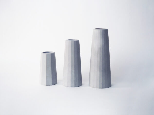 Trois petits vases béton gris clair différentes tailles surfaces facettes
