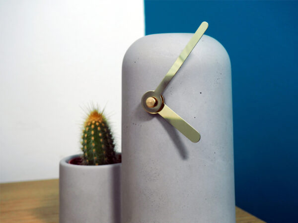 Zoom horloge béton aiguilles dorées cactus coté