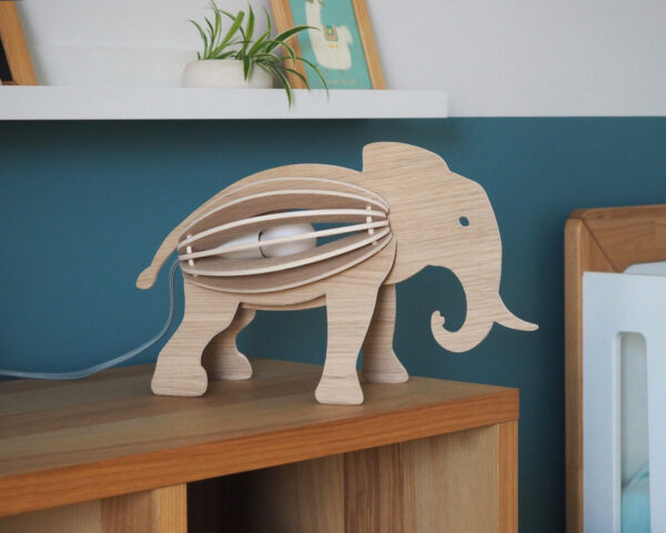 Lampe bois chêne forme éléphant sur meuble bois dans salon appartement