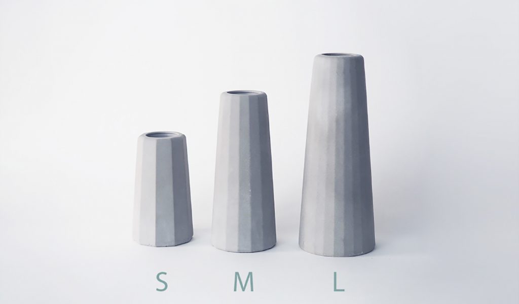 Trois petits vases béton gris clair différentes tailles surfaces facettes